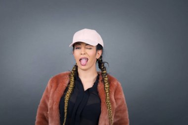 Sevimli genç esmer kadın mutlu bir ifadeyle gözlerini zevkle kırpıyor. Yüz ifadeleri ve insanların duygu konsepti.