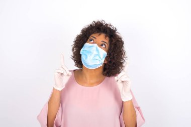 Yüz maskesi takan kadın ve günlük giysiler beyaz stüdyo arka planında izole edilmiş.