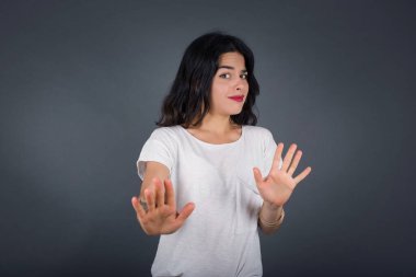 Güzel esmer kız, izole edilmiş arka planda korkmuş ve korkudan dehşete düşmüş, ve tiksindirici ifade iki elinle hareket etmeyi kes, orada kal. Panik konsepti