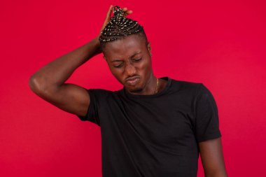 Tüh, ne yaptım ben? Yakışıklı Afro-Amerikan adam korkmuş ve pişmanlık dolu ifadesiyle el ele tutuşuyor. Arka planda dikilen günlük kıyafetlerle..