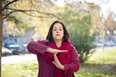 Parkta el kol hareketi yapan orta yaşlı güzel bir Arap kadın.  