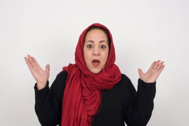 Sürpriz konsept. Şaşırmış olgun Müslüman kadın portresi. İnanamamasına şaşırmış, ağzı açık, elleri yüzüne yakın. Olumlu duygu yüz ifadesi vücut dili.