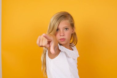 Sarı arka planda işaret eden güzel kız. 