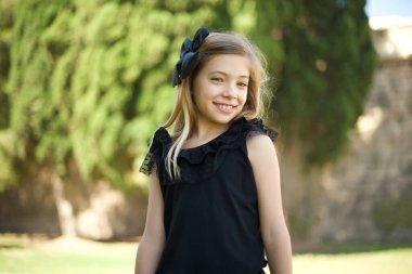 Utangaç kız kameraya bakarak gülümsüyor. Beyaz tenli çekici kız parkta zımpara yapıyor. 