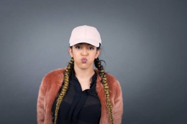 Komik yüzlü, güzel, genç bir kadın. Havayla şişmiş ağız, çılgın bir ifade..