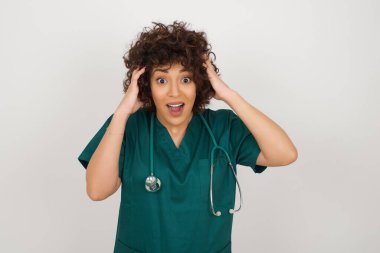 Heyecanlı, sevinçli, Arap doktor kadın tıbbi üniforma giyen iyi haberler aldıktan sonra çığlıklar atıyor, ellerini başının üstünde tutuyor.