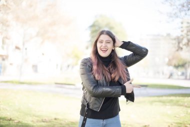 Genç ve güzel bir kadın parkı işaret ediyor. 