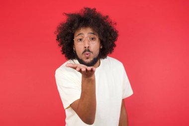 Kızıl duvara öpücük konduran afro saçlı genç adam. 