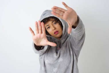 El hareketli parmak çerçevesi. Pijamalı kadın portresi kameraya bakıyor ve el hareketi yapıyor. 