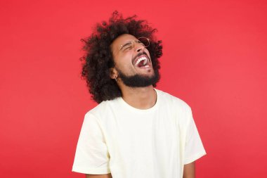 Kızıl duvara gülüp duran afro saçlı genç adam. 