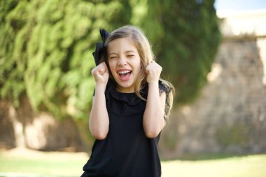 Kafkas kızı başarısını ve zaferini kutluyor yumruklarını neşeyle sıkıyor. Hedeflerine ve hedeflerine ulaşmaktan mutlu olan şanslı kadın. Olumlu duygular, duygular.