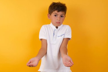 Yakışıklı çocuğun sarı duvara karşı kafası karışık.  