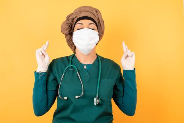 Kazanmak zorundayım. Yeşil üniformalı, neşeli, genç, güzel, Müslüman bir doktor. Parmaklarını çapraz yapıyor, arzulanan dilekler diliyor. Günlük kıyafetler giyiyor, iyi haberleri bekliyor, duvarın üzerinde duruyor.