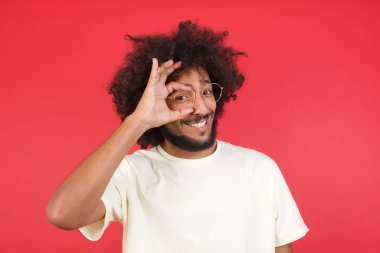 Kızıl duvarda gözlüklü afro saçlı genç adam. 