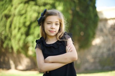 Güzel, kendine güvenen, neşeli, genç bir kızın belinde geniş bir gülümseme, kollarını kavuşturur.