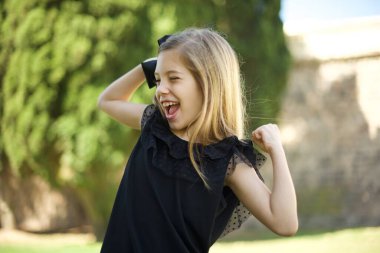 Evet, ben kazandım. Çekici, keyifli ve heyecanlı beyaz kız öğrencinin portresi zaferle yumruklarını kaldırıyor ve zaferle gülümsüyor zevkten sırıtıyor..