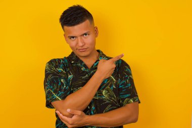 Heyecanlı, modaya uygun İspanyol adam moda reklamcılığı ya da promosyon metinleriniz için arka plan fotokopisi çekilirken mutlu bir şekilde işaret ediyor..