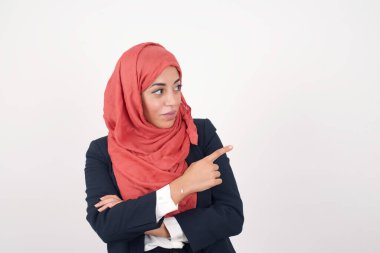 Kamerada poz veren güzel esmer bir kadın. Alengirli bir bakışla ve el kol hareketleriyle. Bayan tasarımcı, işaret parmağıyla harika bir ürün sunuyor. Hareket kavramı.