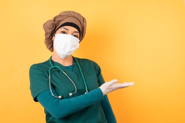 Yeşil üniformalı genç, güzel, Müslüman doktor kadın diyor ki: Vay be, ne kadar heyecan verici, hayret verici bir ifade, boş uzayda boş elle bir şey gösteriyor. Reklam kavramı.