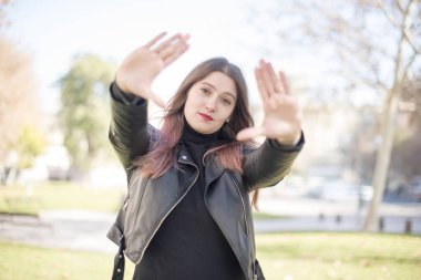 Parkta avuçlarını gösteren güzel bir kadın.