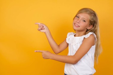 Sarı arka planda işaret eden güzel kız. 