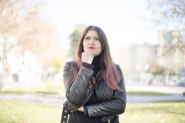 Parkta düşünen genç ve güzel bir kadın