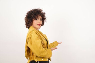 Süet ceketli güzel bir kadın stüdyo çekimi yapıyor.