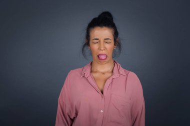 Kızgın, tatminsiz bir kadın iğrenç bir ifadeye sahiptir. Çünkü çekici olmayan bir şey görür. Surat asar, gri arka planda izole olur..