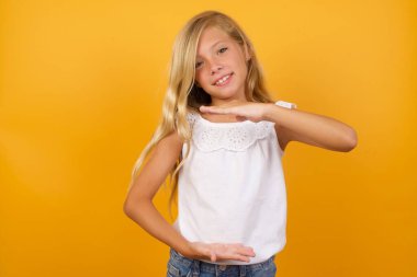 Sarı arka planda bir şey gösteren tatlı kız. 