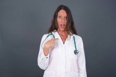 Şaşırmış güzel doktor bayan öğrencinin sersemlemiş olması, kendini parmağıyla göstererek 