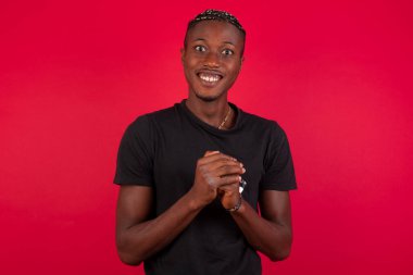 Stüdyonun arka planında yarım boy Afro-Amerikan portresi var. Genç, duygusal, şaşkın, ağzı açık bir adam. İnsani duygular, yüz ifadesi kavramı. Moda renkleri.