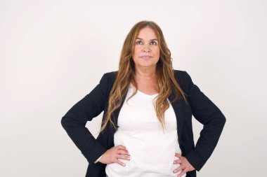 Neşeli orta yaşlı bir kadının yukarı bakıp bir şeyler düşündüğü belden yukarı pozlar. Ellerini kalçaya koy, yüz ifadenden şüphe et. Gri duvara yaslanmış bir şey olup olmadığını merak ediyorum..