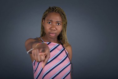 Kapalı alanda çekilen Afro-Amerikan kadının gri arka plandaki görüntüsü yarışmayı seçtiğini gösteriyor..