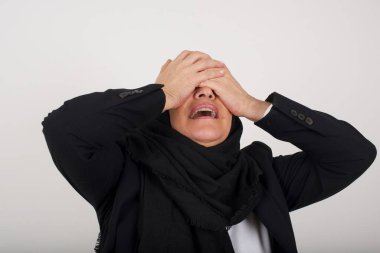 Şok olmuş siyah tesettürlü Müslüman kadın ellerini yüzüne koydu gözleri kapadı ve umutsuzluk ve hüsranla bağırdı..