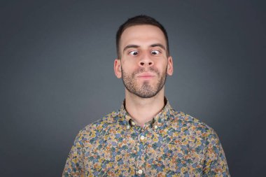 Komik komedyen gözlerini şaşı yapar, dudaklarını büzer, bütün gün çalıştıktan sonra suratını buruşturur. Tuhaf ifadeli cahil adam yalnız eğleniyor, aptalı oynuyor. Beyaz kazak giyiyor.