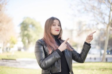 Genç ve güzel bir kadın parkı işaret ediyor.
