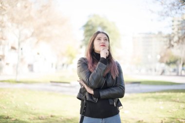 Genç ve güzel bir kadın parka bakıyor. 