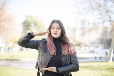 Parkta elleri olan genç ve güzel bir kadın.