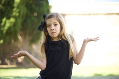 Güzel kız şüphe ifadesi, şaşkınlık ve merak konsepti, belirsiz gelecek omuz silkiyor.