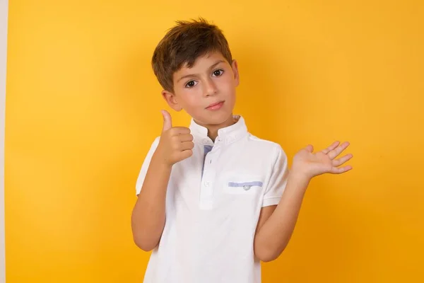 可爱的男孩 大拇指靠着黄色的墙 — 图库照片
