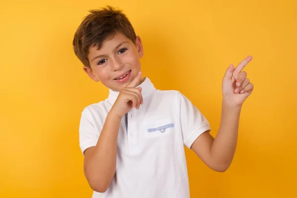 Yakışıklı Çocuk Sarı Duvara Işaret Ediyor — Stok fotoğraf