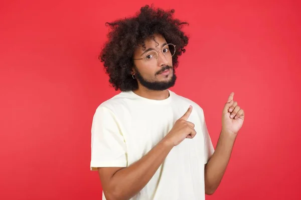 Junger Mann Mit Afro Haaren Zeigt Gegen Rote Wand — Stockfoto