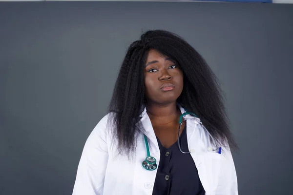 Beautiful face of sad  African American woman doctor crying desperate and depressed with tears on her eyes suffering pain and depression isolated on grey background in sadness facial expression and emotion concept.