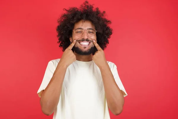 Joven Con Pelo Afro Mostrando Sonrisa Contra Pared Roja — Foto de Stock