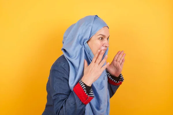 Portret Muzułmanki Średnim Wieku Hidżabie Stojącej Żółtym Tle Wstrząśniętym Wyrazem — Zdjęcie stockowe