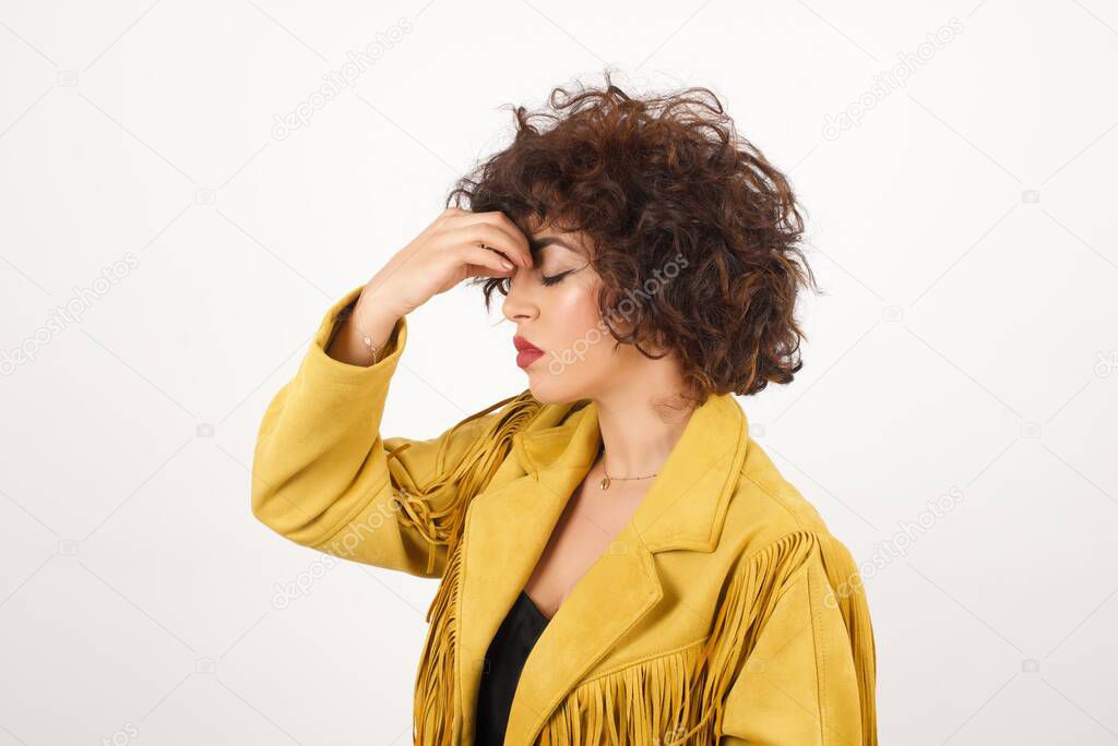 Beautiful  woman in suede jacket with headache  studio shot