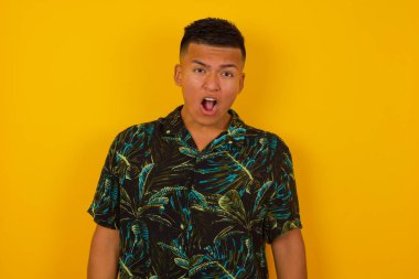 Etkileyici yüz ifadeleri. Şok olmuş İspanyol erkek, çenesini düşük tutuyor boş duvarda gördüklerinden sersemlemiş hissediyor.