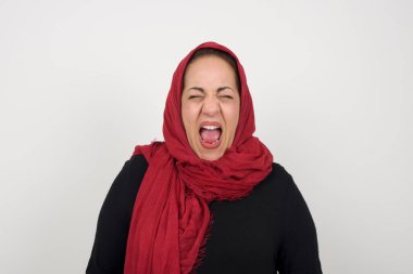 Stresli Müslüman kadın panik içinde bağırıyor, dehşet içinde gözlerini kapatıyor, ellerini başının üstünde tutuyor, en iyi arkadaşı hakkında dehşet verici haberler ya da felaketler öğreniyor, buna inanamıyorum. İnsanlar, stres, sıkıntı. Stüdyoda poz veren başörtüsü takan orta yaşlı bir Arap kadın.