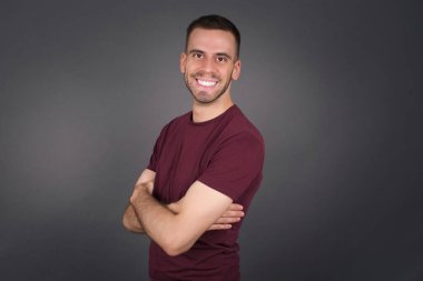 İçerde kollarını kavuşturmuş neşeli beyaz bir adamın görüntüsü. Kameraya bakıp gülümsüyor. Kendinden emin çocuk..