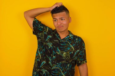 Tüh, ne yaptım ben? Yakışıklı İspanyol adam korkmuş ve pişmanlık dolu bir ifadeyle elini tutuyor. Arka planda dikilen günlük kıyafetlerle..